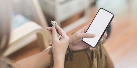Close-up view of young female listening to the music with smartphone during the relaxing time at comfortable roomの写真素材