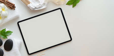 Spa therapy concept, Top view of blank screen laptop with black stones and accessories for massages on white backgroundの写真素材