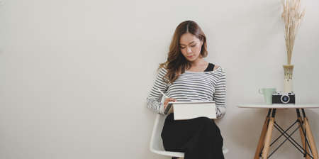 Successful female designer working on her project with tablet in modern workplaceの写真素材