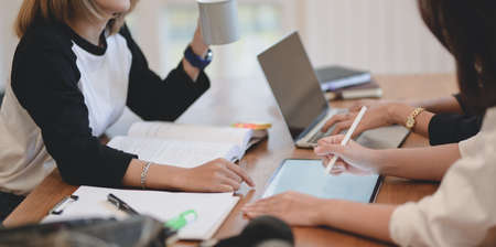 Close-up view of young professional business team discussing the plan about the upcoming project together in comfortable roomの写真素材