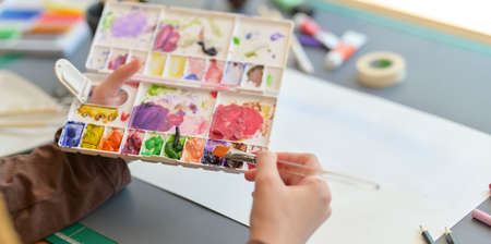 Close-up view of professional female artist painting on her project with water colours in creative studioの写真素材