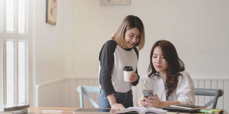 Young professional freelancer discussing the project together in comfortable office roomの写真素材