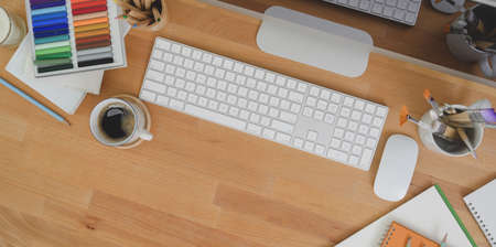 Top view of designer workplace with desktop computer and office supplies on wooden table with copy spaceの写真素材
