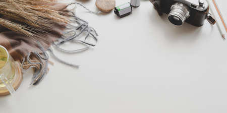 Minimal workplace with vintage camera and office supplies with decorations on white table background, top view with copy spaceの写真素材