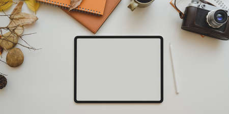 Autumn workplace concepts : Blank screen tablet and office supplies on white table with copy spaceの写真素材