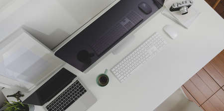 Top view of desktop computer and laptop computer with copy space in minimal office roomの写真素材