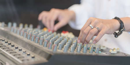 Close-up view of young man setting up the digital mixer.の写真素材