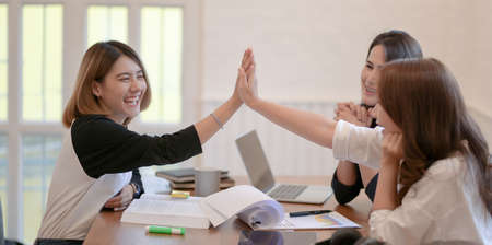 Cheerful startup team discussing the plan together with positive attitude in modern office roomの写真素材