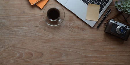 Top view of modern rustic workplace with laptop computer, camera and office supplies.の写真素材