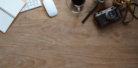 Top view of modern rustic workplace with camera and office supplies with copy space.の写真素材