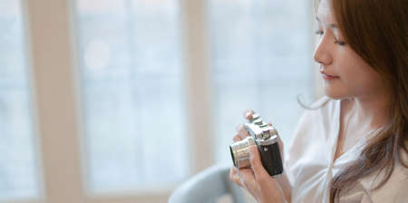 Portrait of beautiful professional photographer holding camera for shootingの写真素材