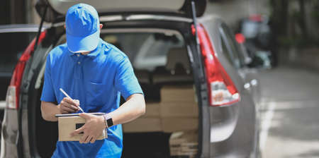 Professional delivery man working with parcel boxes, customer order in the carの写真素材