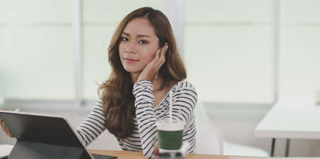 Professional young designer editing her project on tablet in her comfortable workplaceの写真素材