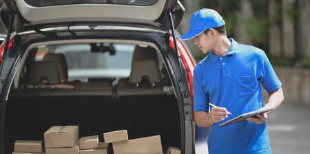 Delivery man checking orders on tablet,
preparing the products to customer.