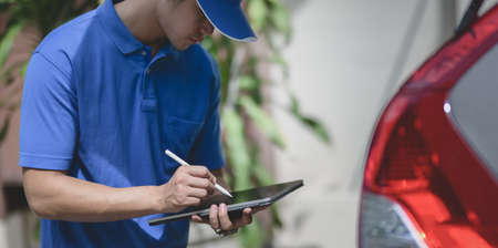 Delivery man checking orders on tablet,preparing the products to customers