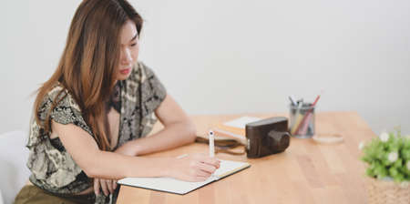Professional young designer editing her project on tablet in her comfortable workplace