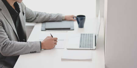 Cropped shot of young professional businessman working on his project while writing his idea on notebook.の写真素材