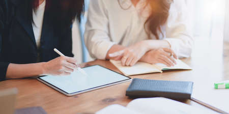 Cropped shot of female freelancers working on their project with tablet in modern workplaceの写真素材