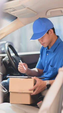 Beautiful businesswoman sitting at the back set of the car while heading to the officeの写真素材