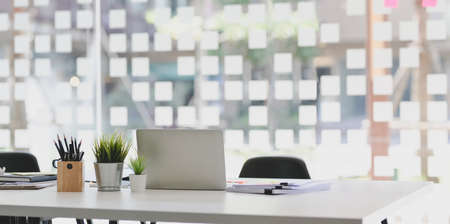 Modern office style with open laptop computer with office supplies and documents on white tableの写真素材