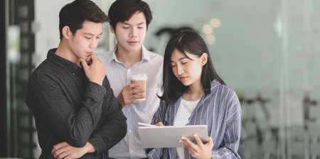 Young female businesswoman showing her strategy to team members with tablet in the meeting roomの写真素材