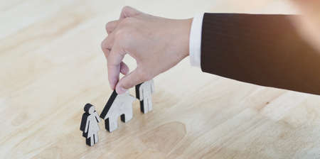 Family care insurance concept : businessman touching a family care insurance modelの写真素材
