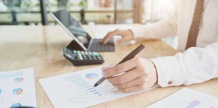 Close-up view of male accountant compiling and analysing financial information to his clientの写真素材