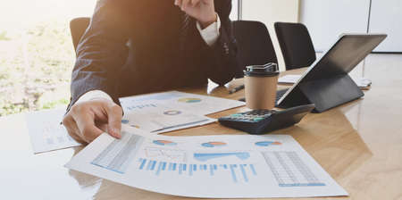 Close-up view of young handsome accountant preparing financial reports for the next meeting in modern officeの写真素材