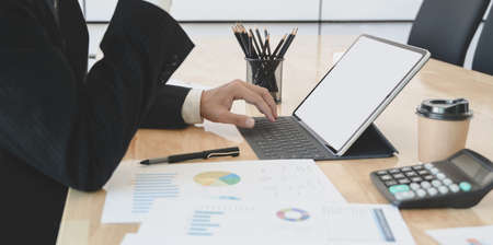 Close-up view of young accountant summarising the current financial status while using tabletの写真素材