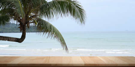 Empty rustic desk with beautiful tropical ocean with coconut tree in the background.の写真素材