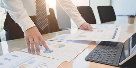 Cropped shot of young accountant preparing profit and loss statements for his client by comparing the charts and graphsの写真素材