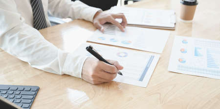 Cropped shot of young accountant preparing and reviewing budgets document in his office roomの写真素材