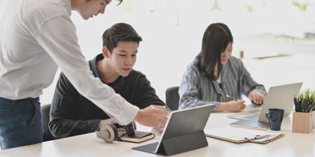 Young professional businessman explaining his idea to his team members in the meeting room.の写真素材
