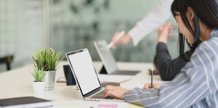 Young adorable businesswoman working on her project while typing on laptop computerの写真素材