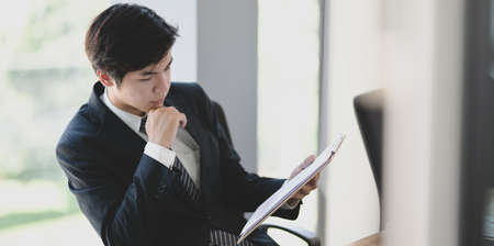 Handsome young businessman checking the data on the document preparing before meetingの写真素材
