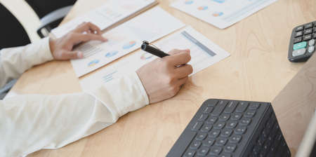 Close-up view of professional accountant planing his financial reports with charts and graphs