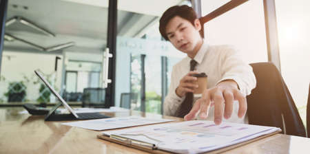 Professional male accountant compiling and analysing financial information to his client in office roomの写真素材