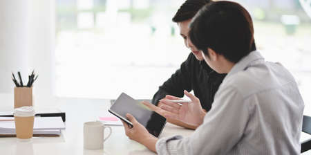 Young professional businessman explaining his idea to his coworkers with tabletの写真素材