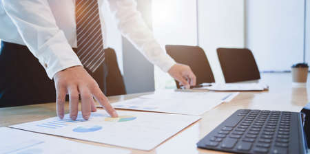 Young hard-working businessman analysing his investment plan with charts and graphsの写真素材