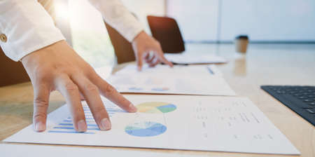 Close-up view of young professional businessman planing his strategy for his upcoming project with charts and graphsの写真素材