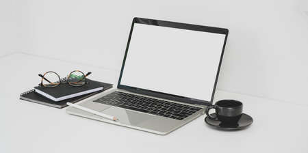Minimal photographer workplace with open blank screen laptop and office suppliesの写真素材