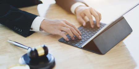 Male lawyer working on a laptop and providing legal document for his clientの写真素材