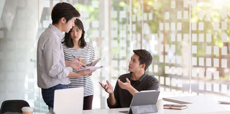 A group of young startup people brainstorming their strategy together in modern workplaceの写真素材