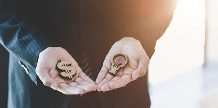 Loans for real estate concept : businessman holding dollar model represent the idea of saving the moneyの写真素材