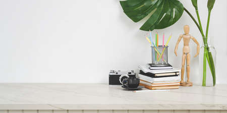 Minimal designer workplace with camera and office supplies on white table with copy spaceの写真素材