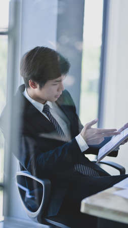 Young professional accountant analysing the case while using calculator