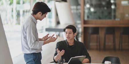 Young professional businessman explaining his idea to his coworkers with tabletの写真素材