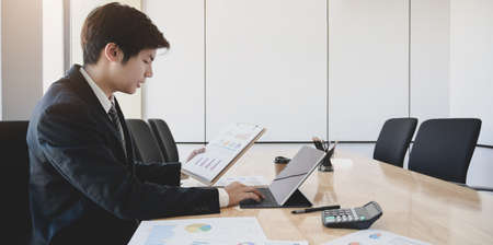 Professional businessman working on his current project while using tablet and chartsの写真素材