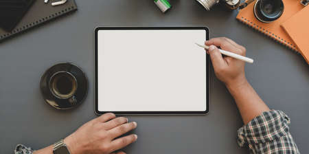 Top view of professional photographer working on his project with blank screen tablet on trendy workplaceの写真素材