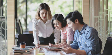 Group of young professional UI graphic designer discussing on their smartphones templates togetherの写真素材